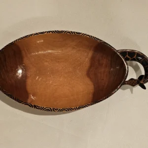 Handcrafted wooden serving dish with tribal patterns, perfect for serving or display in home decor.