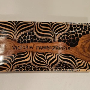 Hand-carved wooden tray with tribal patterns, perfect for home decor.